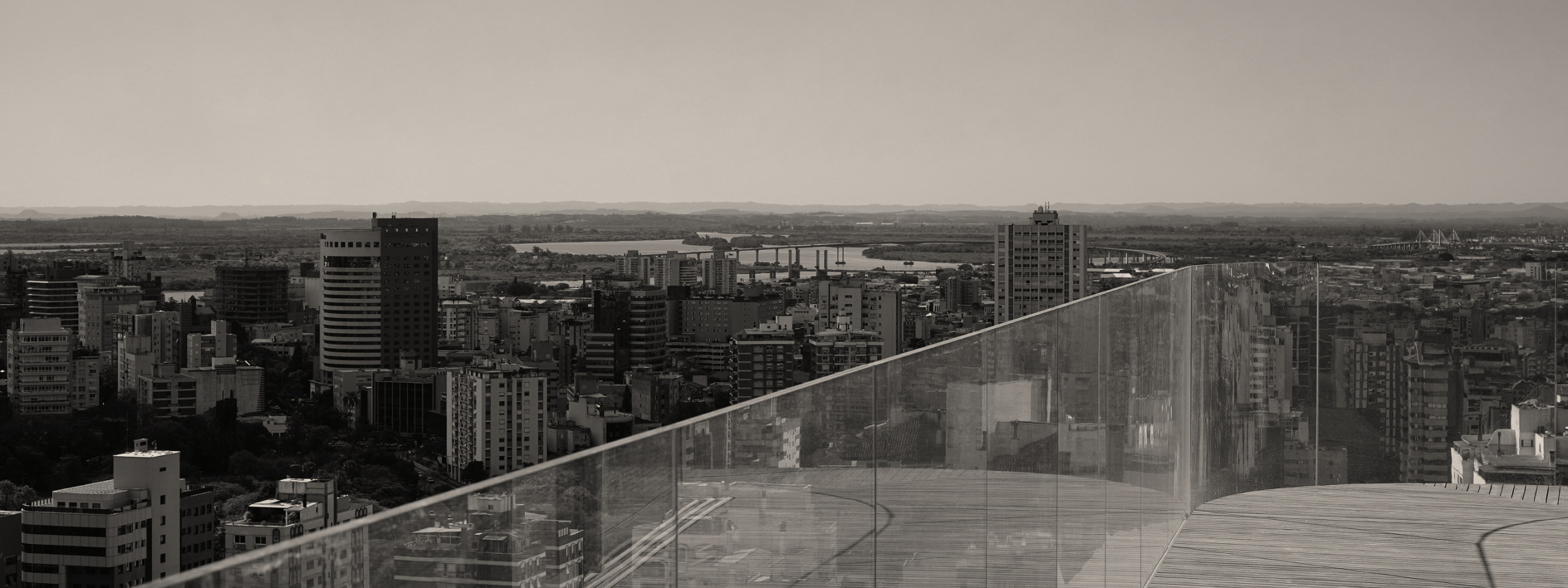 Vista da sacada do Brava mostra cidade e ponte do Guaíba ao fundo.