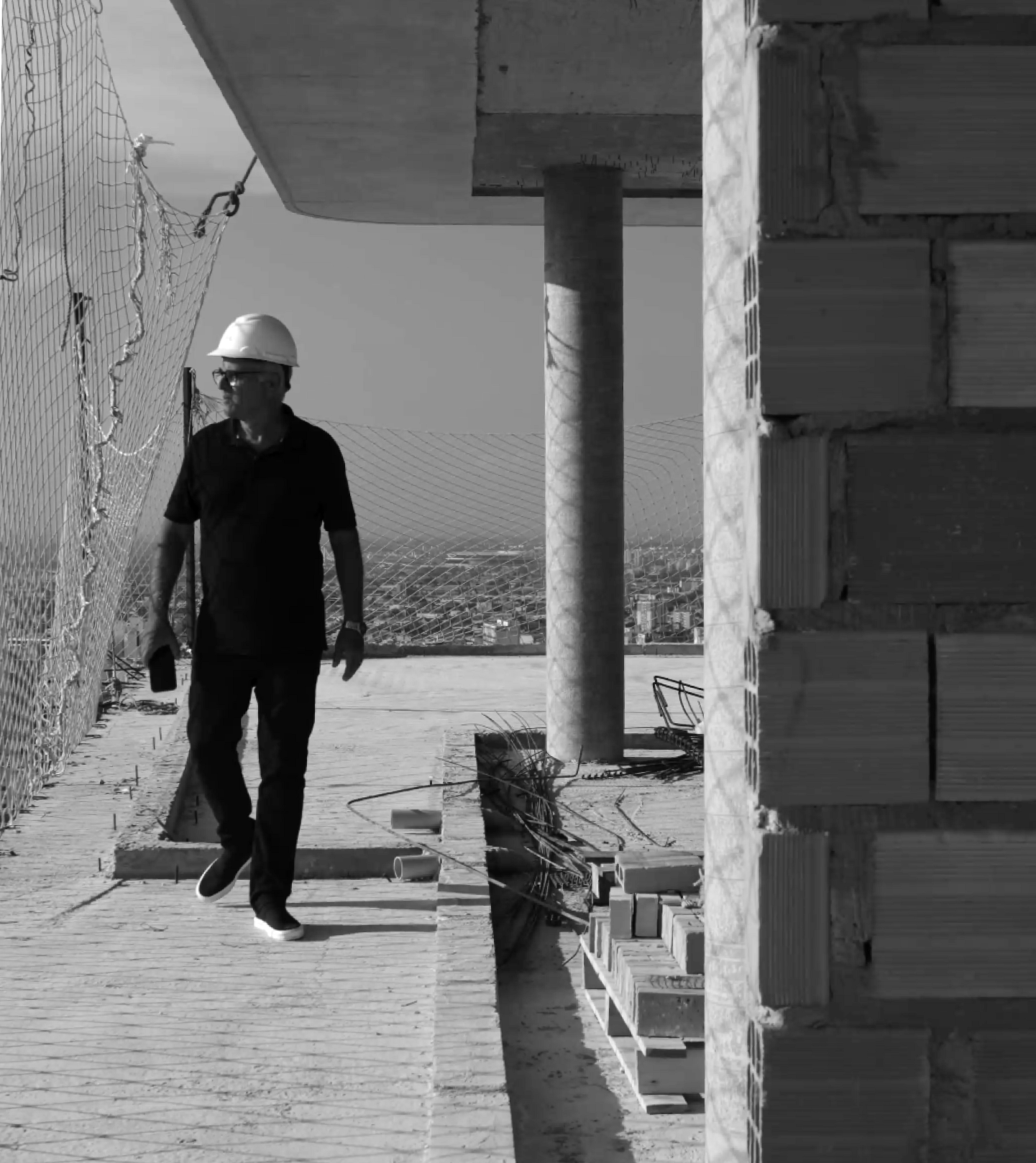 Arquiteto Zé Barros Lima caminha na obra do Brava com vista da cidade ao fundo.