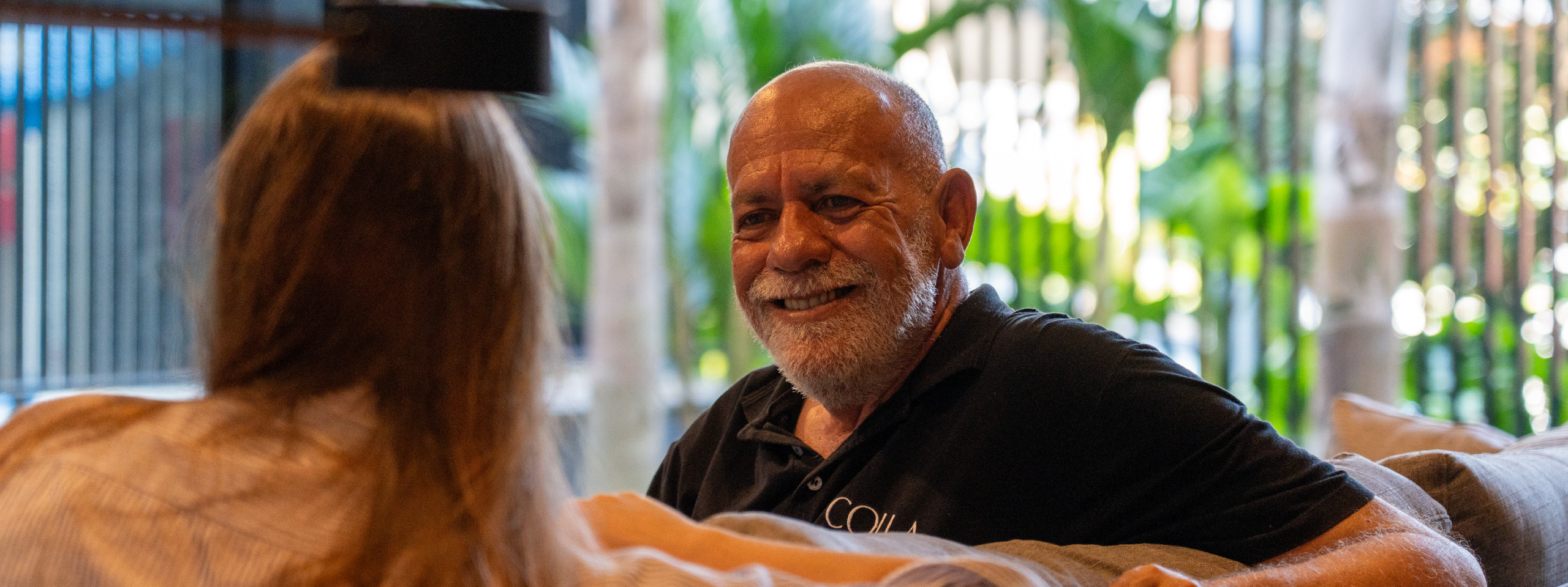 Nereu sorrindo e conversando com mulher.