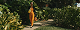 Mulher caminhando no jardim de acesso ao empreendimento Faria Santos.