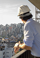 Homem observa a cidade apoiado sobre guarda corpo em empreendimento Colla.