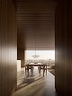 Sala de jantar integrada, com painel de madeira, luminária linear e esquadria de piso a teto.